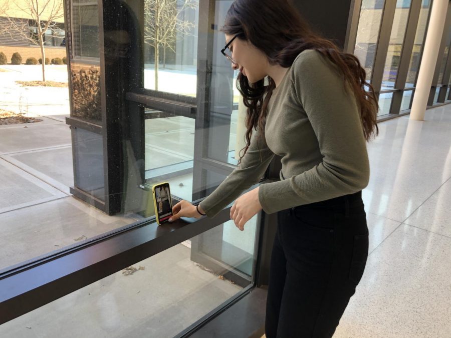 Wendy Avalos 21 setting up her phone on the window in the commons, preparing to Renegade in front of passing students. 
