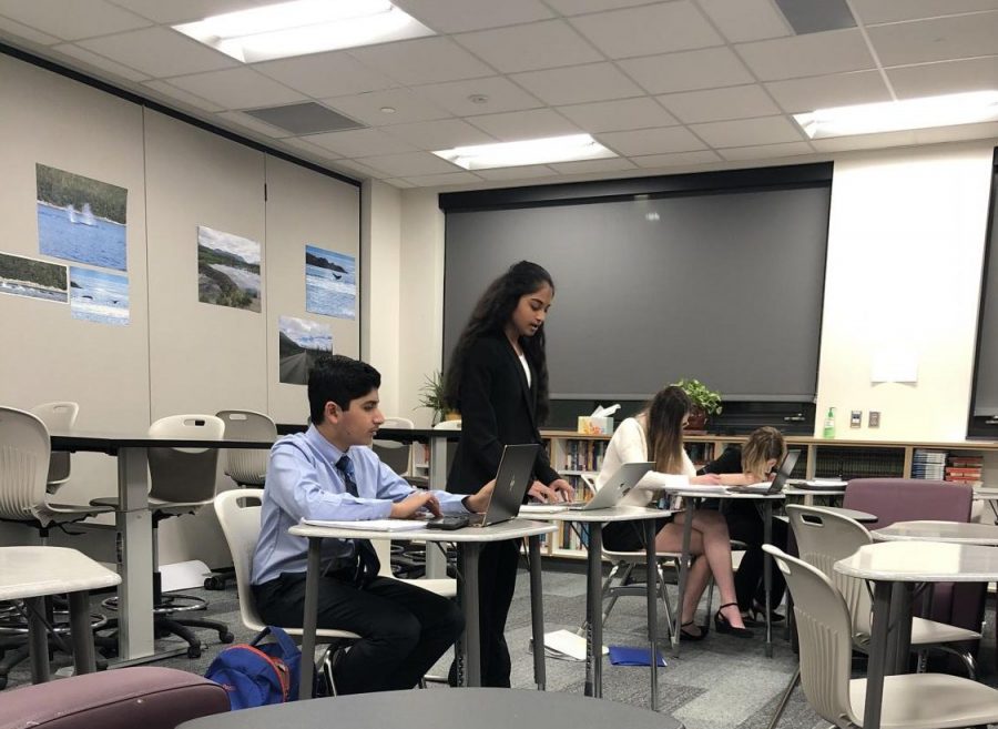 Anjali Kumar 23 gives her first speech on the benefits of universal basic income while her partner Eshaan Chandani 23 preps for his rebuttal in their second round of Public Forum. Public Forum is a debate event in which teams of two people debate the monthly topic before a judge who then chooses the winner. 