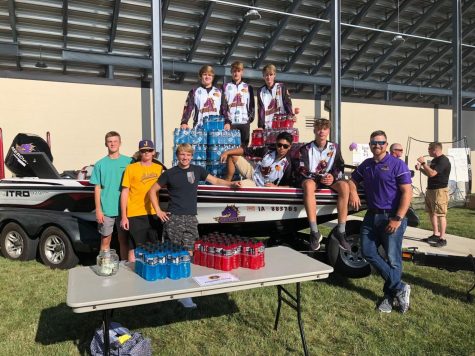 Some members of the fishing club along with their sponsor, Justin Lewis, sitting on their boat.