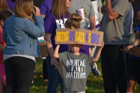 An elementary student holds a sign outside the board meeting. Supporters of the five-day return to learn plan gathered in front of the district office Oct. 8 to voice their opinions. The board voted 5-2 to scrap the hybrid plan and planned for students to return to school every day Oct. 26.
