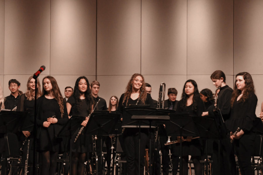 (Center) Emma Dummermuth 22 standing with her fellow band members as the audience applauds Wind Symphony.