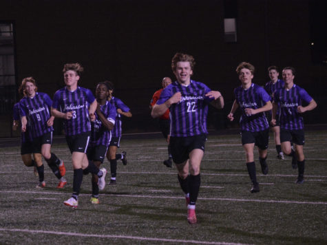 Will Sheeley ‘22 and field number 22 runs to the sidelines, grinning after scoring a goal, the Dragons trail behind. 