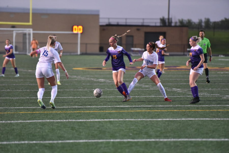 Johnstons Ella Smith (15) dribbles between Waukee Northwest players May 17, 2022