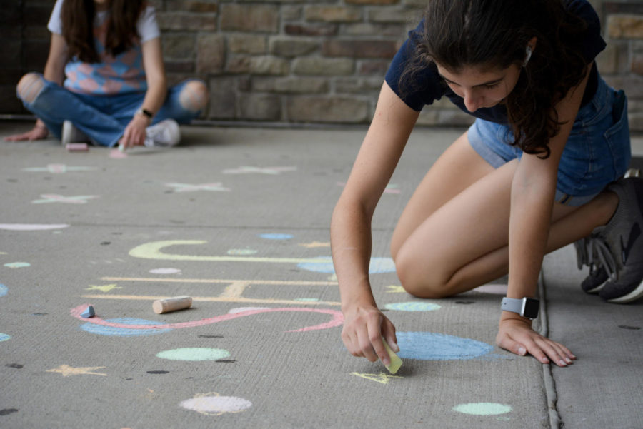 Sophia Metzger 25 focuses as she does precise chalk art for homecoming 2022. 